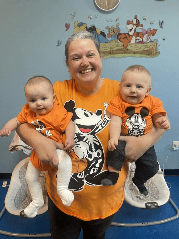 Teacher holding two infants